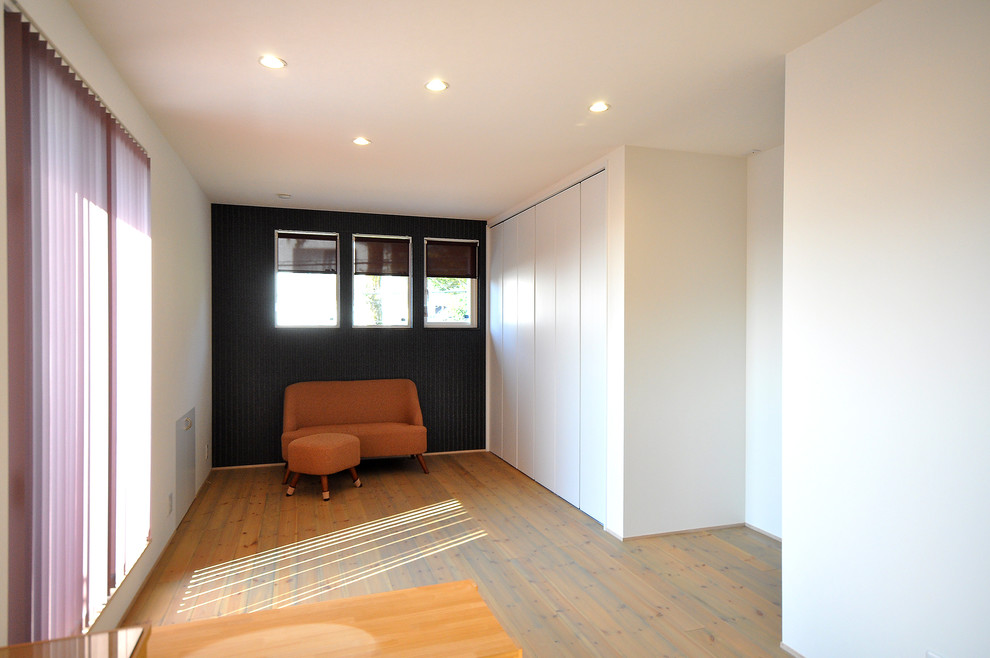 Esempio di un soggiorno minimalista chiuso con pareti bianche, pavimento in legno massello medio, nessun camino e pavimento marrone
