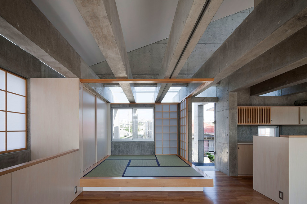 Family room - zen medium tone wood floor and brown floor family room idea in Other with gray walls