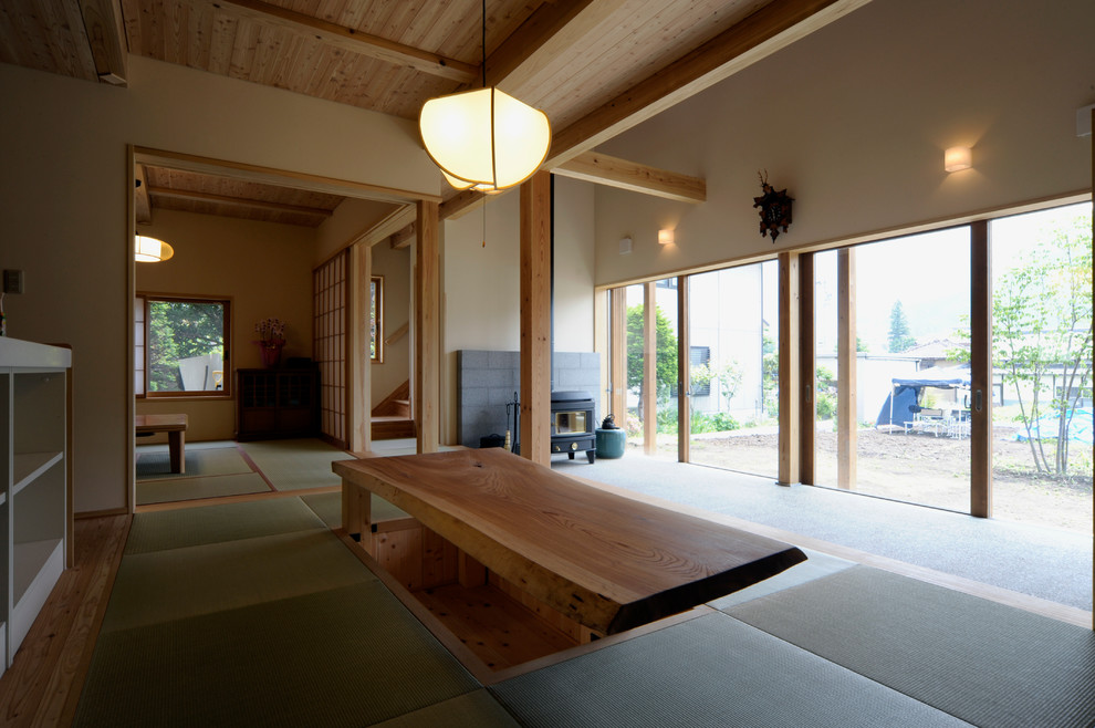 Example of a zen tatami floor family room design in Other with beige walls, a standard fireplace and a concrete fireplace