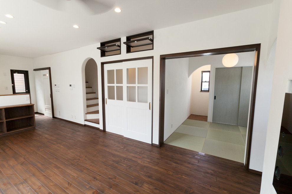 Réalisation d'une salle de séjour minimaliste de taille moyenne et ouverte avec un mur blanc, parquet foncé et un sol marron.