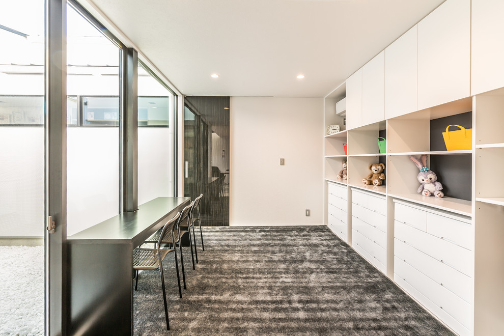 Immagine di un soggiorno minimalista con pareti bianche e pavimento grigio