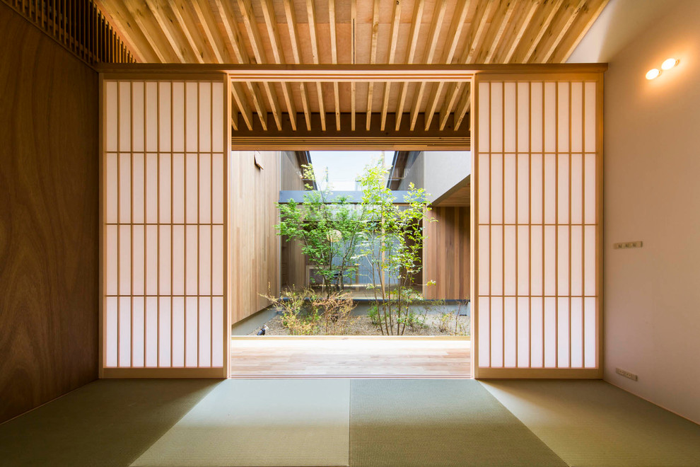 Imagen de sala de estar de estilo zen sin chimenea y televisor con paredes beige y tatami