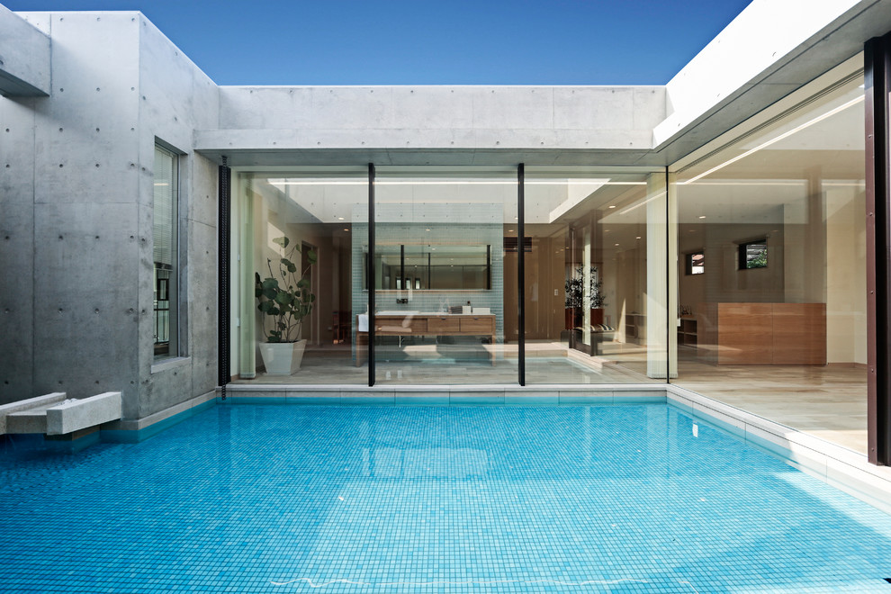 Пример оригинального дизайна: большой бассейн на внутреннем дворе в современном стиле с фонтаном и покрытием из плитки