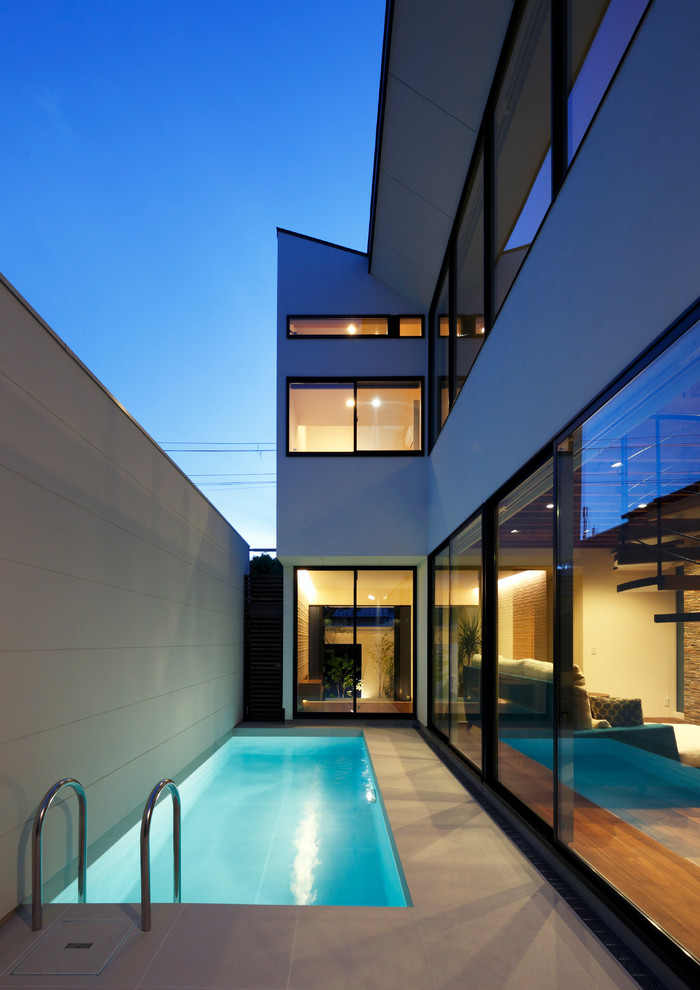 Источник вдохновения для домашнего уюта: прямоугольный бассейн на внутреннем дворе в стиле модернизм с покрытием из плитки