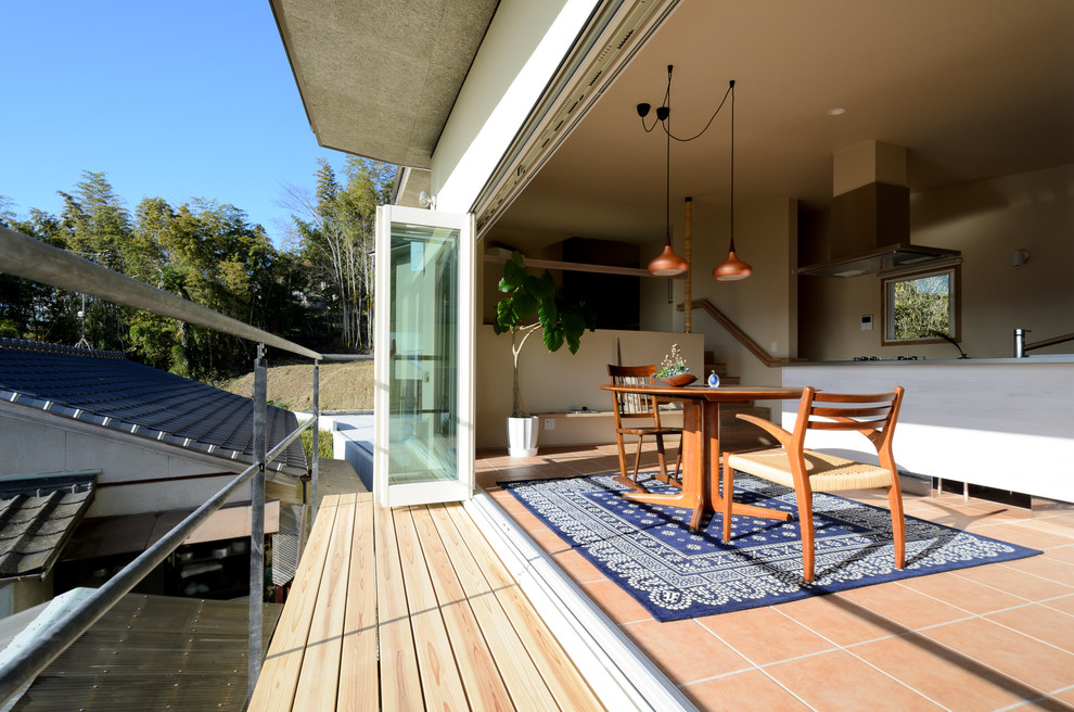 Cette image montre un petit balcon minimaliste avec une extension de toiture et un garde-corps en métal.