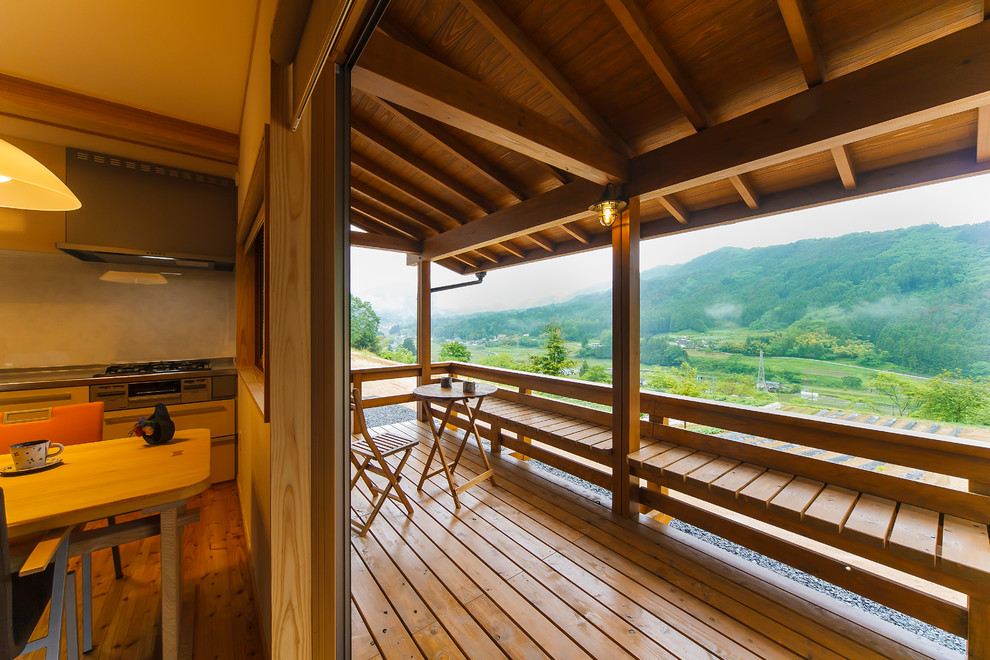 Idées déco pour un balcon asiatique avec une extension de toiture et un garde-corps en bois.
