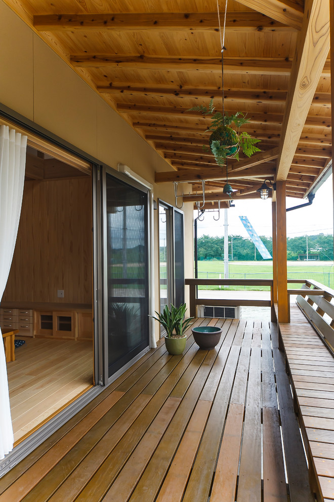 Design ideas for a world-inspired wood railing balcony in Other with a roof extension.