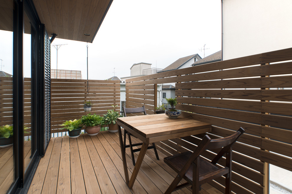 Ejemplo de balcones campestre con jardín de macetas y barandilla de madera