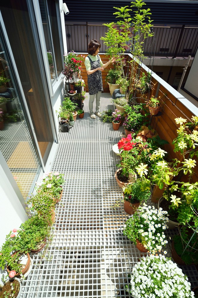 Foto de balcones moderno de tamaño medio sin cubierta con jardín de macetas y barandilla de varios materiales