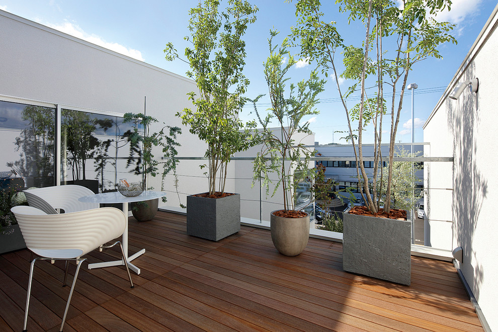 Idee per un balcone moderno con un giardino in vaso, nessuna copertura e parapetto in materiali misti