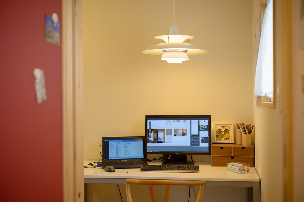 Modelo de despacho nórdico de tamaño medio sin chimenea con paredes blancas, suelo de madera en tonos medios y escritorio independiente