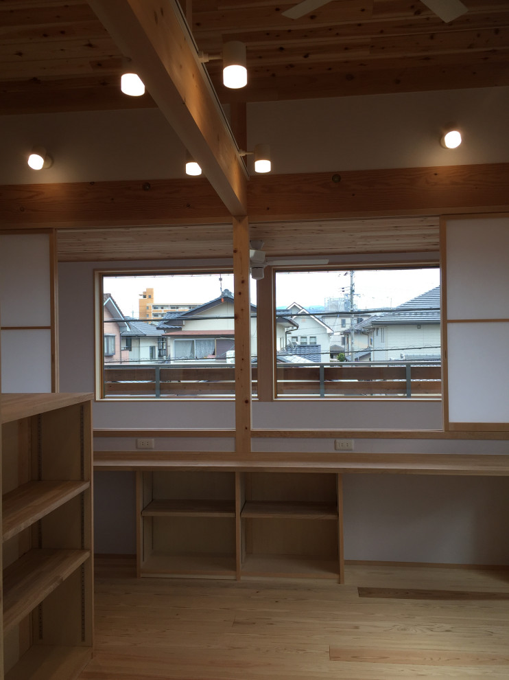 Cette photo montre un bureau chic de taille moyenne avec une bibliothèque ou un coin lecture, un mur blanc, parquet clair, un bureau intégré, un plafond en bois et du papier peint.