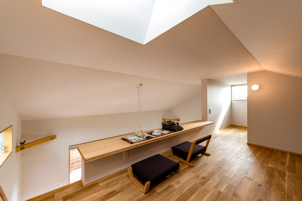 Study room - small scandinavian built-in desk medium tone wood floor and brown floor study room idea in Other with white walls