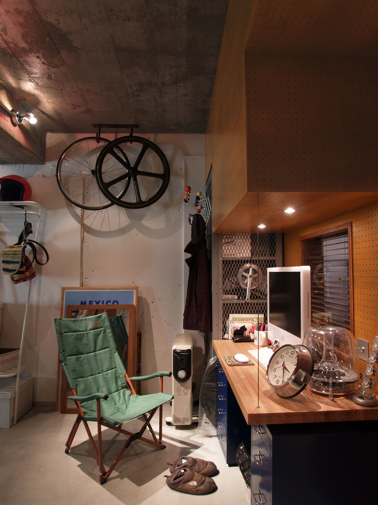 東京23区にある小さなインダストリアルスタイルのおしゃれな書斎 (グレーの壁、コンクリートの床、暖炉なし、造り付け机) の写真