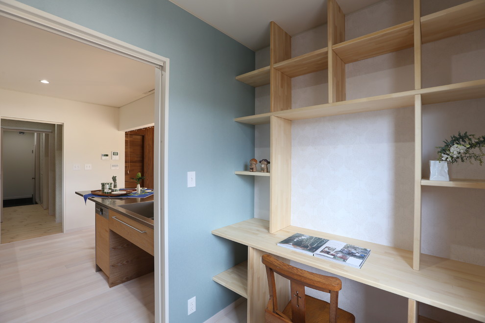 他の地域にある北欧スタイルのおしゃれな書斎 (青い壁、淡色無垢フローリング、造り付け机) の写真