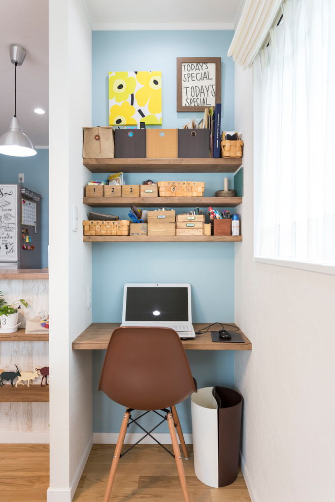 Cette image montre un bureau nordique avec un mur multicolore, un sol en bois brun, un bureau intégré et un sol marron.