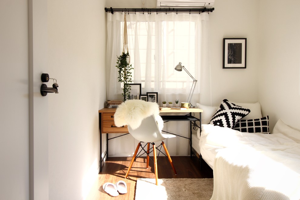 На фото: маленький кабинет в скандинавском стиле с белыми стенами, темным паркетным полом, отдельно стоящим рабочим столом и коричневым полом для на участке и в саду с