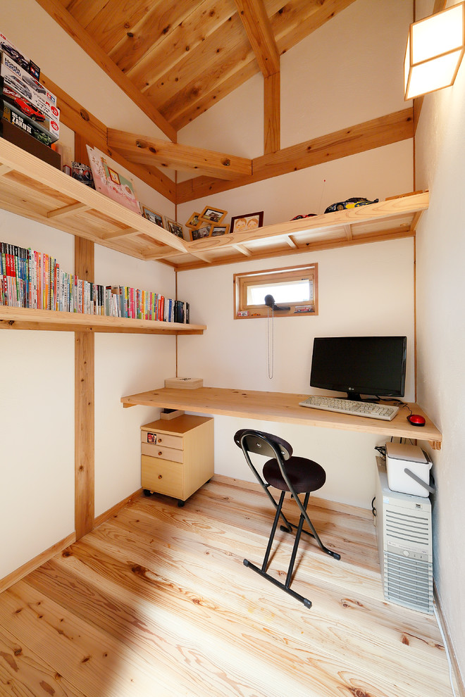Idéer för orientaliska arbetsrum, med vita väggar, mellanmörkt trägolv, ett inbyggt skrivbord och brunt golv