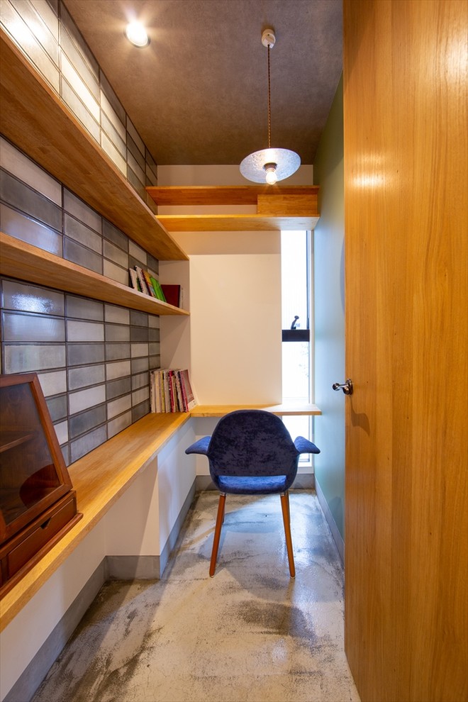 Пример оригинального дизайна: маленький кабинет в стиле модернизм с разноцветными стенами, встроенным рабочим столом и серым полом для на участке и в саду