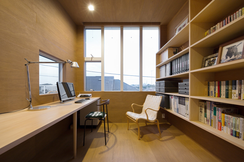 Idee per un ufficio minimalista con pareti marroni, parquet chiaro, nessun camino e scrivania incassata