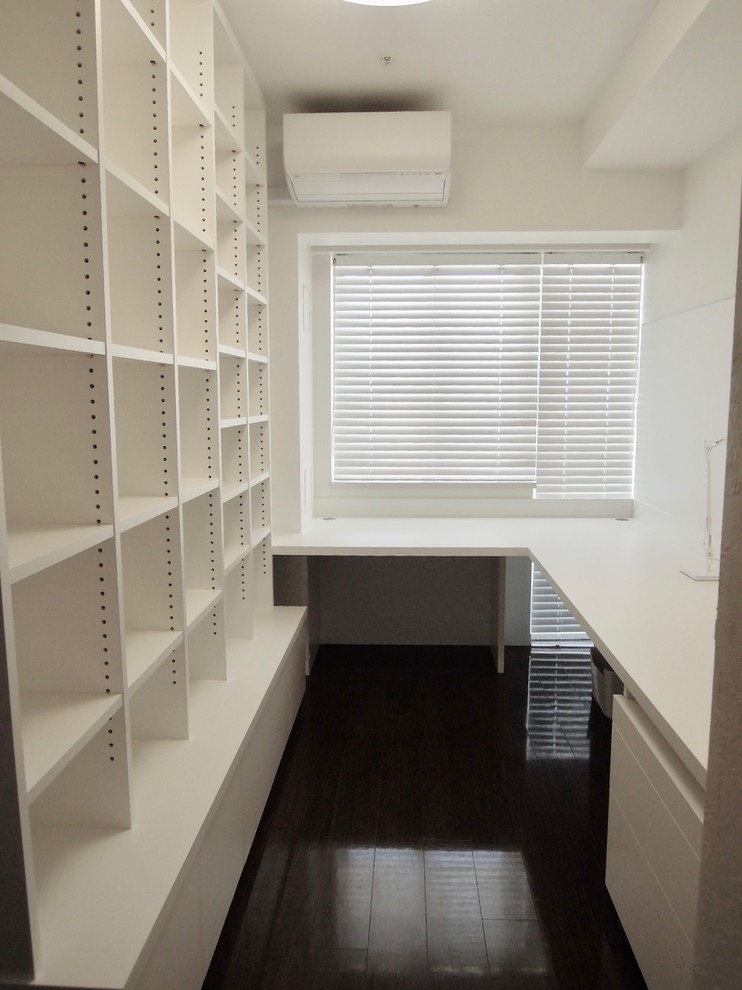 Idéer för ett litet modernt hemmastudio, med vita väggar, plywoodgolv, ett inbyggt skrivbord och brunt golv