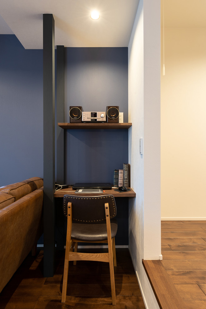 他の地域にあるミッドセンチュリースタイルのおしゃれなホームオフィス・書斎 (青い壁、無垢フローリング、造り付け机、茶色い床) の写真