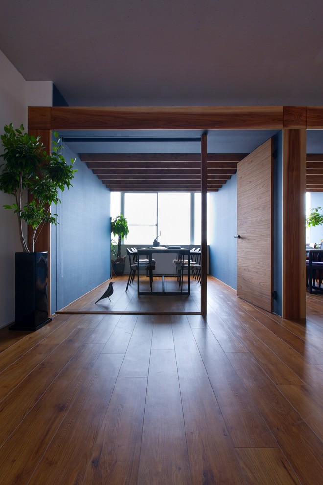 Kleines Mid-Century Arbeitszimmer mit Studio, blauer Wandfarbe, Vinylboden, freistehendem Schreibtisch und beigem Boden in Sonstige