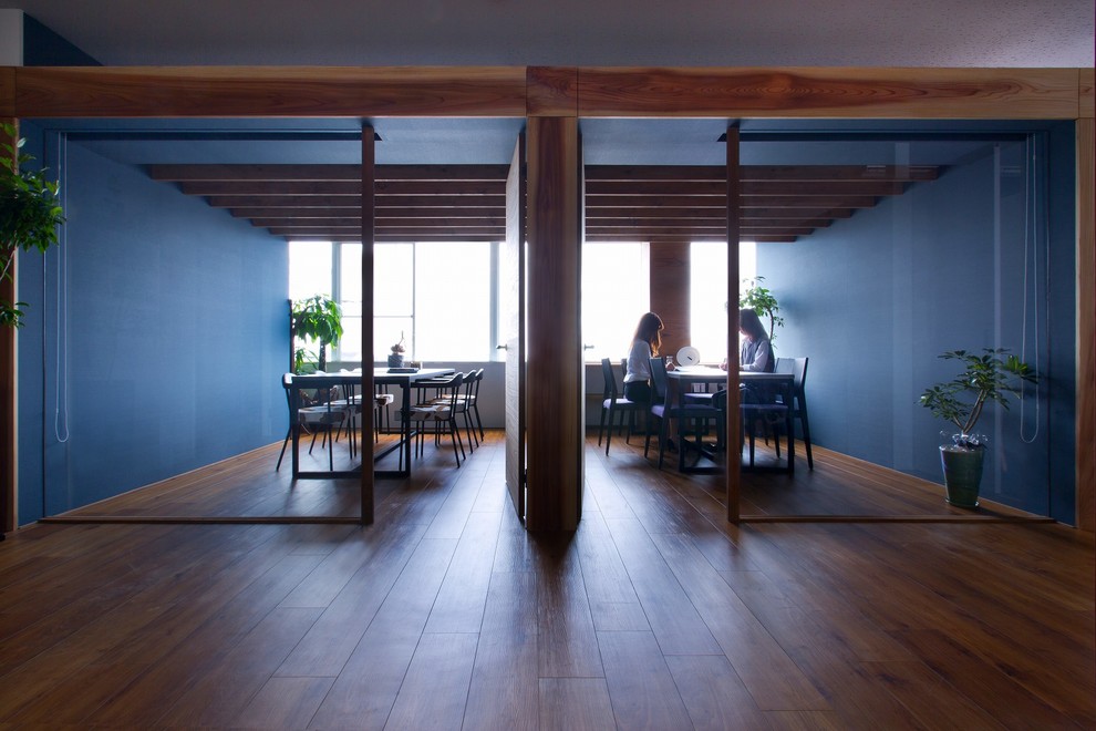 Immagine di un piccolo atelier minimalista con pareti blu, pavimento in vinile, scrivania autoportante e pavimento beige