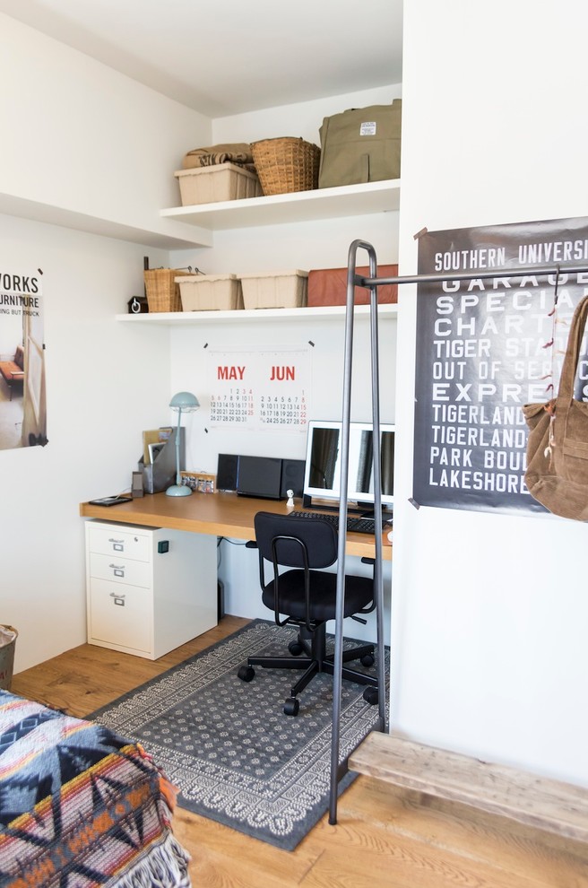 Esempio di un piccolo ufficio etnico con pareti bianche, pavimento in legno massello medio, nessun camino e scrivania incassata