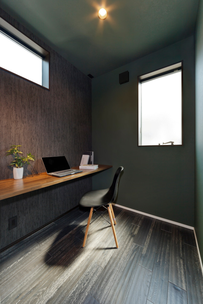 На фото: рабочее место с коричневыми стенами, темным паркетным полом, встроенным рабочим столом, коричневым полом, потолком с обоями и обоями на стенах с