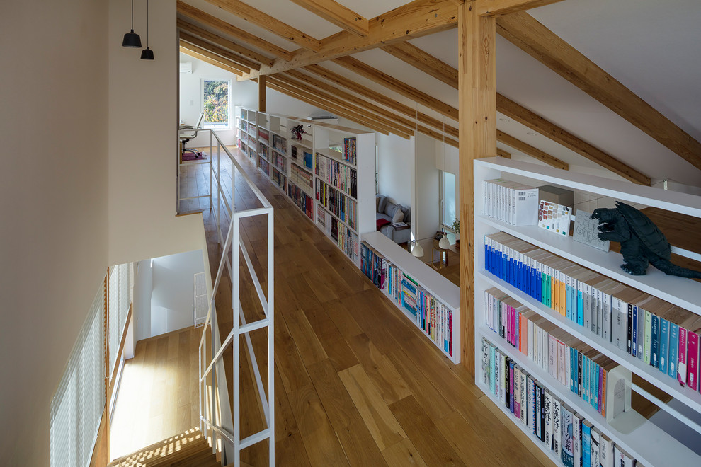 Idées déco pour un bureau moderne avec une bibliothèque ou un coin lecture et un mur blanc.