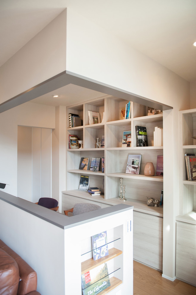 Inspiration för ett mellanstort funkis hemmabibliotek, med vita väggar, ljust trägolv, ett inbyggt skrivbord och vitt golv