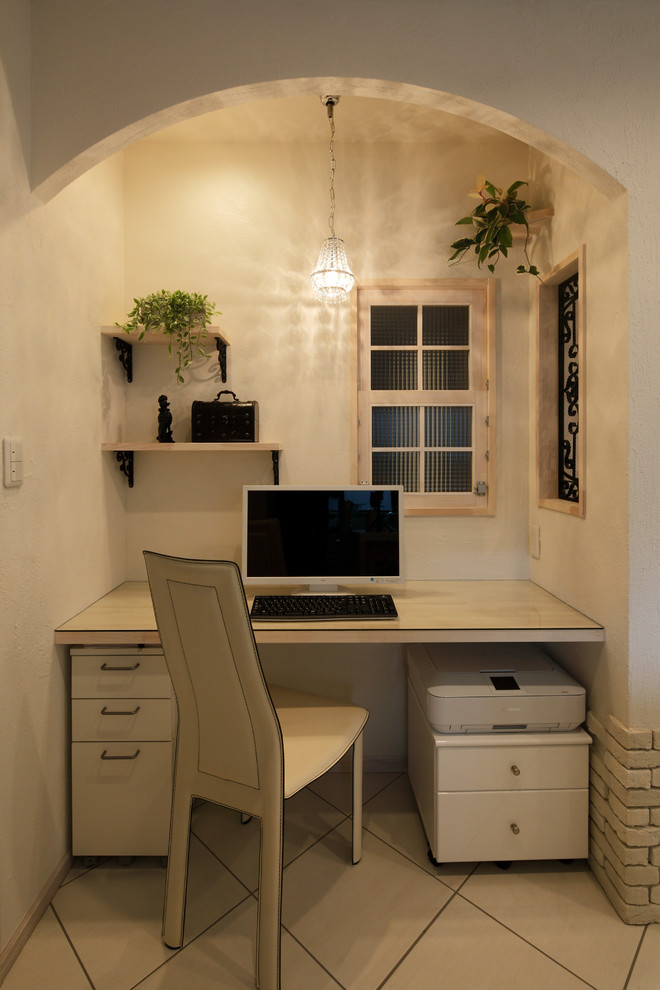 Идея дизайна: кабинет в средиземноморском стиле с белыми стенами, встроенным рабочим столом и бежевым полом