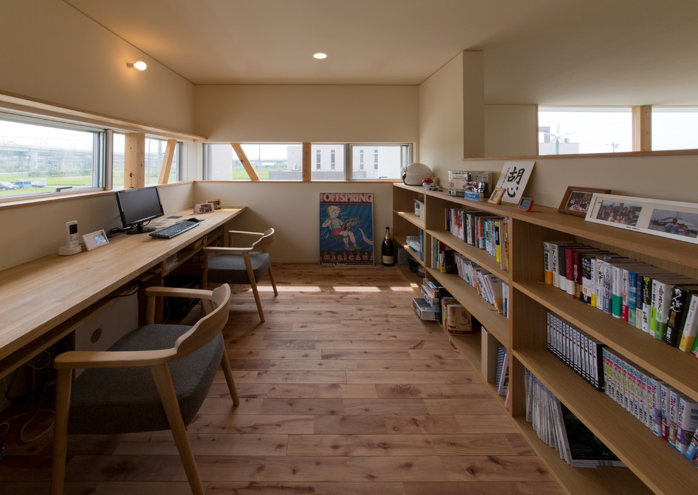На фото: кабинет в современном стиле с бежевыми стенами, паркетным полом среднего тона, встроенным рабочим столом и коричневым полом с
