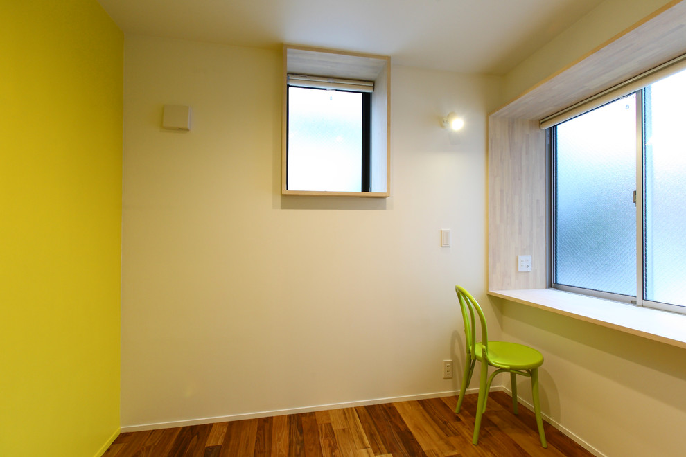 Foto di un ufficio minimalista di medie dimensioni con pavimento in legno massello medio, scrivania incassata, pavimento marrone e pareti verdi