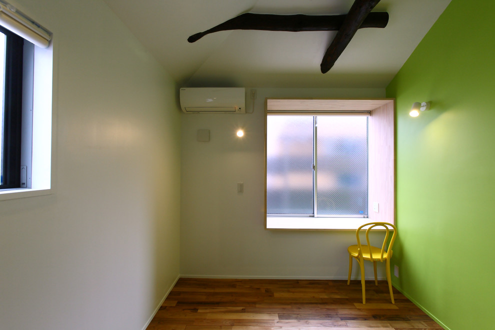 Mittelgroßes Modernes Arbeitszimmer mit Arbeitsplatz, grüner Wandfarbe, braunem Holzboden, Einbau-Schreibtisch und braunem Boden in Tokio