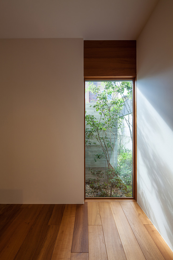 Exempel på ett mellanstort modernt arbetsrum, med vita väggar, mellanmörkt trägolv och brunt golv