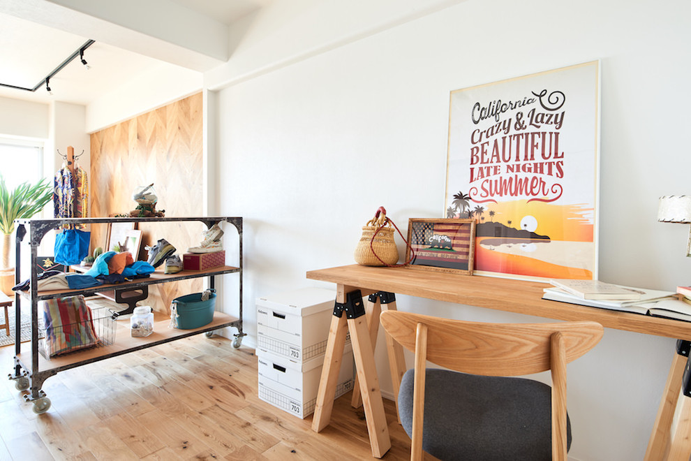Photo of a coastal study in Other with white walls, light hardwood flooring, a freestanding desk and beige floors.
