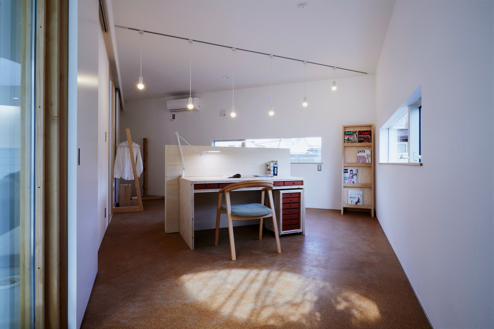 Свежая идея для дизайна: маленькое рабочее место в скандинавском стиле с белыми стенами, пробковым полом, отдельно стоящим рабочим столом, коричневым полом и потолком с обоями для на участке и в саду - отличное фото интерьера