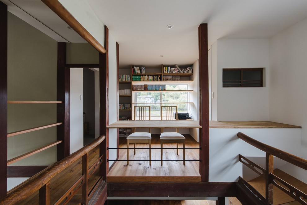 Ispirazione per uno studio etnico con pareti bianche, pavimento in legno massello medio, scrivania incassata e pavimento marrone