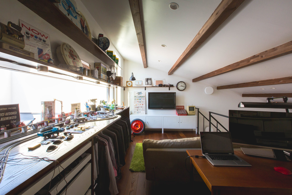 Immagine di un ufficio con pareti bianche, parquet scuro, stufa a legna, cornice del camino in metallo, scrivania autoportante e pavimento marrone