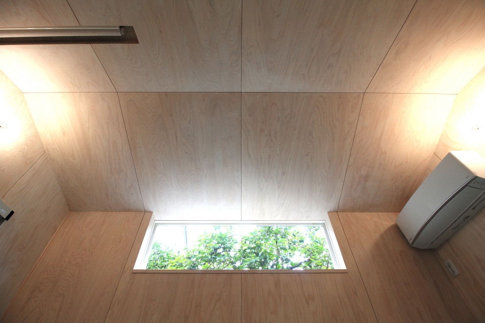 Immagine di un piccolo atelier minimal con pareti beige, moquette, soffitto in legno e pareti in legno