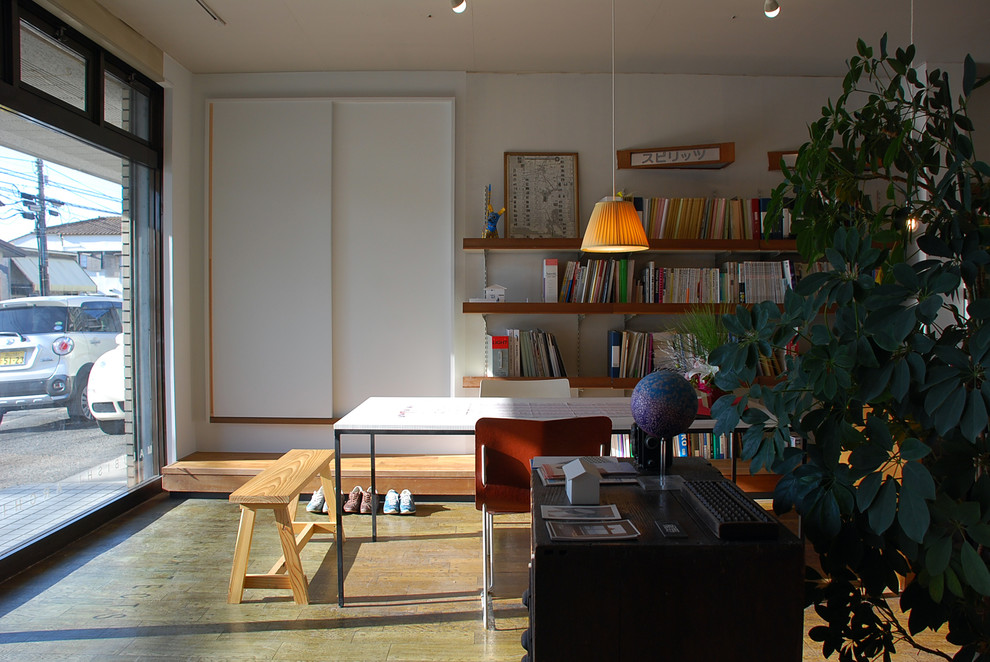 Modelo de estudio minimalista con paredes blancas, suelo de linóleo, escritorio independiente y suelo marrón