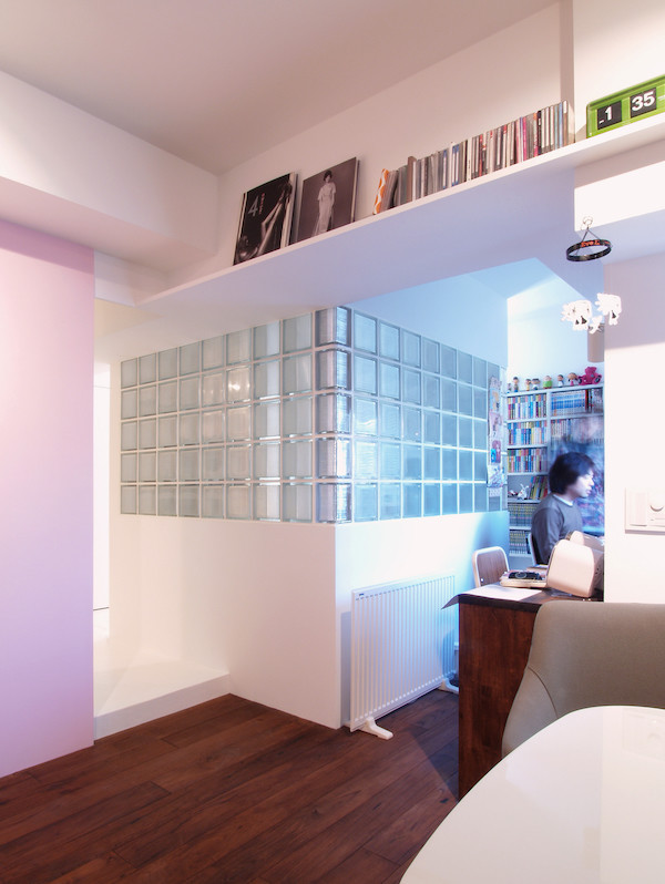 Inspiration för små industriella hobbyrum, med vita väggar, mellanmörkt trägolv och ett fristående skrivbord