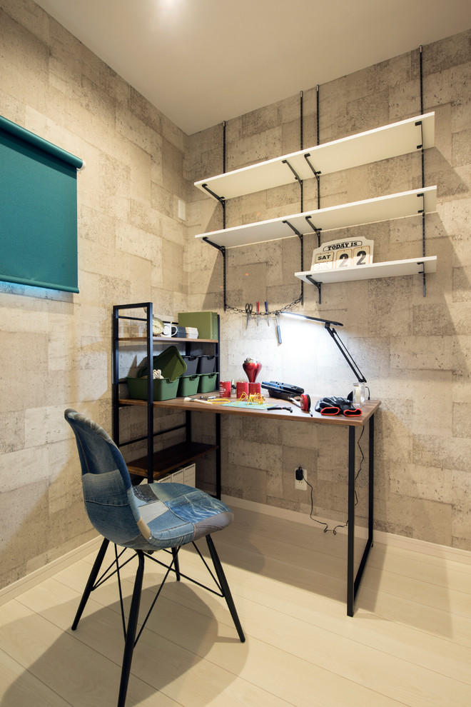 This is an example of an urban home office in Other with grey walls, a freestanding desk, beige floors and light hardwood flooring.