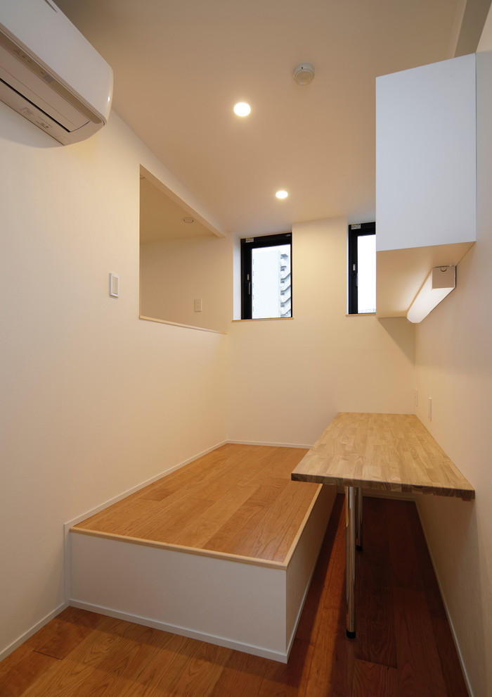 Стильный дизайн: маленькое рабочее место в стиле модернизм с белыми стенами, деревянным полом, встроенным рабочим столом и бежевым полом без камина для на участке и в саду - последний тренд