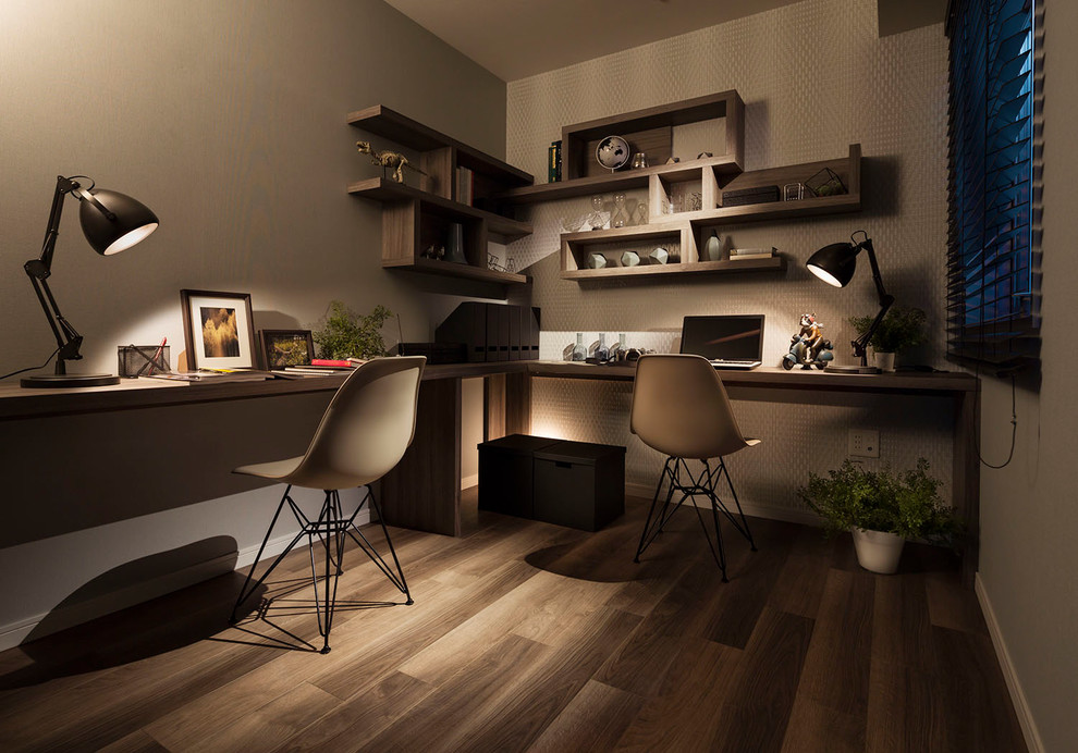 Modern inredning av ett litet arbetsrum, med grå väggar, målat trägolv, ett inbyggt skrivbord och grått golv