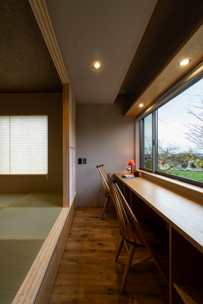 Idee per un piccolo studio moderno con pareti grigie, pavimento in legno massello medio, scrivania incassata e pavimento marrone