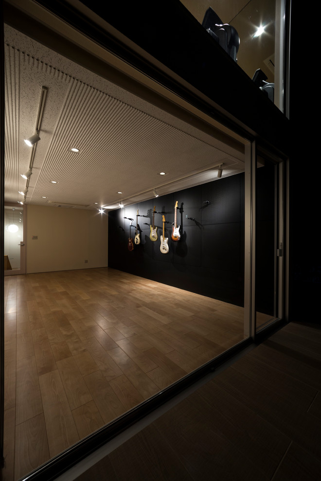 Foto di un atelier contemporaneo di medie dimensioni con pareti nere, parquet chiaro e nessun camino