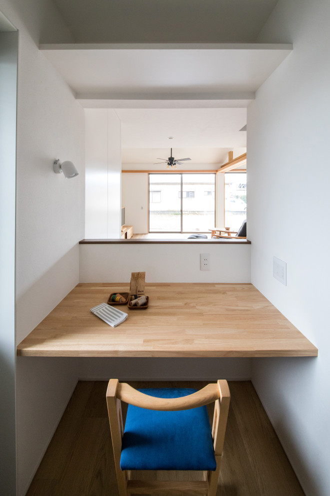 На фото: кабинет среднего размера в стиле модернизм с местом для рукоделия, белыми стенами, полом из винила, встроенным рабочим столом и бежевым полом без камина с